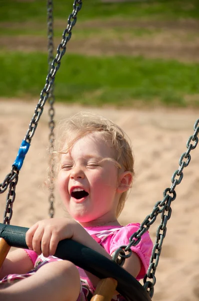 Schattig klein meisje op een schommel plezier — Stockfoto