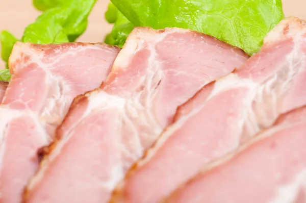 Macro shot of ham and lettuce on a wooden plate — Stock Photo, Image