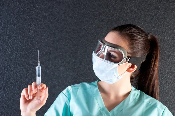 Nurse or doctor in pilot glasses with syringe and mask — Stock Photo, Image