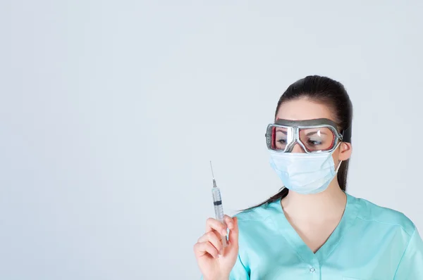Nurse or doctor in pilot glasses with syringe and mask — Stock Photo, Image