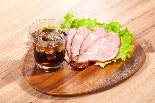 Prosciutto e lattuga con vetro di una cola su un piatto di legno — Foto Stock