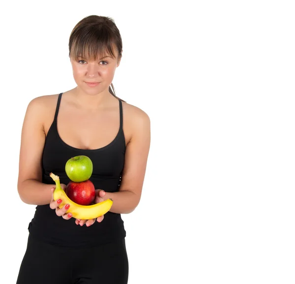 Hermosa mujer joven fitness con plátanos y manzanas . — Foto de Stock