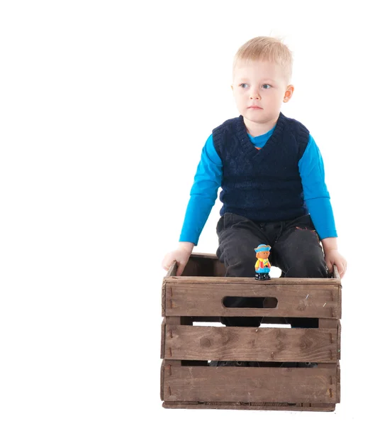 Kleiner Junge in Holzkiste — Stockfoto