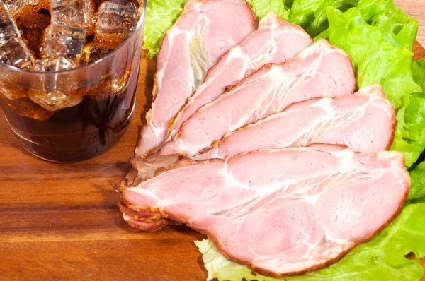 Schinken und Salat mit einem Glas Cola auf einem Holzteller — Stockfoto