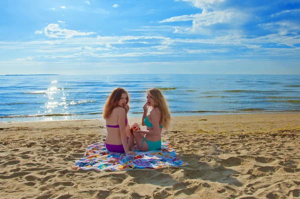 Due belle giovani donne sedute su un asciugamano su una spiaggia — Foto Stock