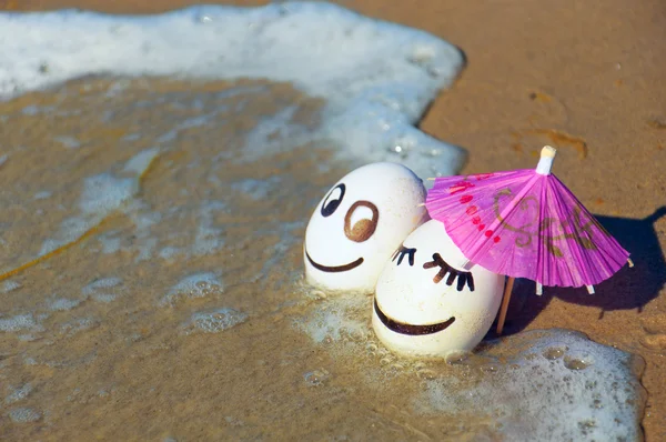 Páscoa ovos engraçados sob guarda-chuva em uma praia — Fotografia de Stock