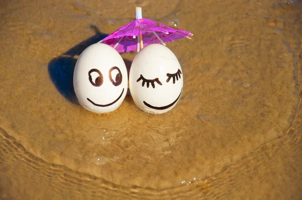 Pâques oeufs drôles sous parapluie sur une plage — Photo