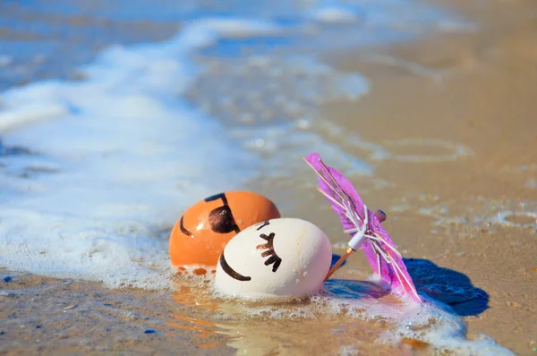 Los huevos de Pascua divertidos bajo el paraguas en la playa — Foto de Stock