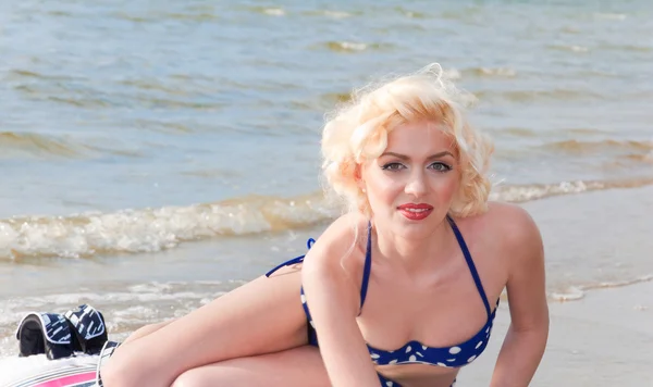 Bonita modelo rubia como Marilyn Monroe con tabla de surf en una playa —  Fotos de Stock
