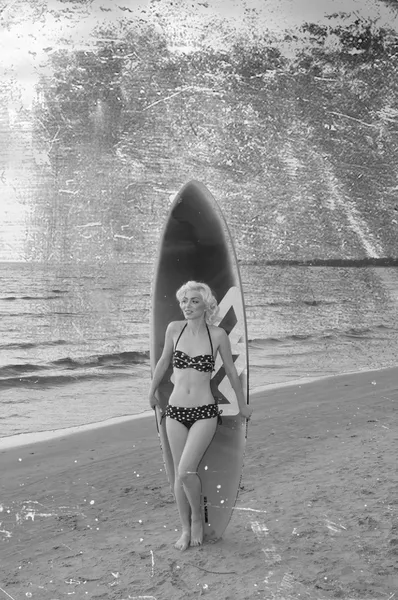 Pretty blond girl model like Marilyn Monroe with surfing board on a beach Stock Picture