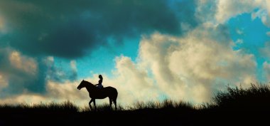 bir Dağı üzerinde mavi gökyüzü üzerinde horseback binici