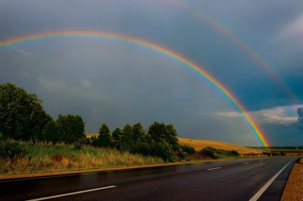 Arco-íris sobre estrada — Fotografia de Stock