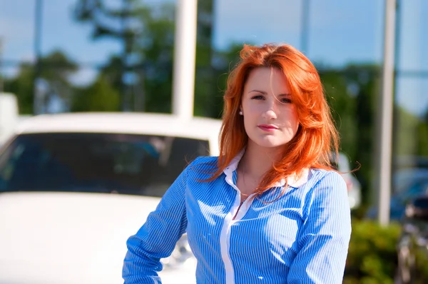 Business woman with red hair in front of office building. — Stock Photo, Image