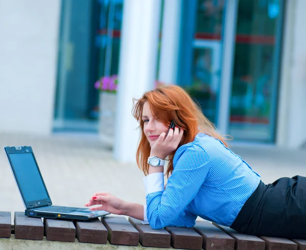 Business woman posing with a laptop in a front of office building — Stock Photo, Image