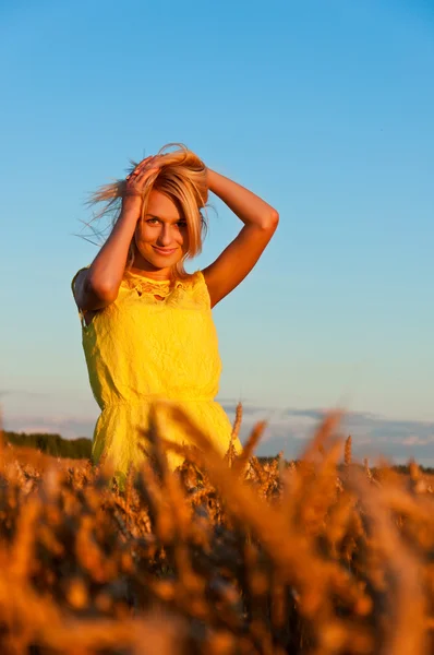 Happy womanin yellow dress in golden wheat — Stock Photo, Image