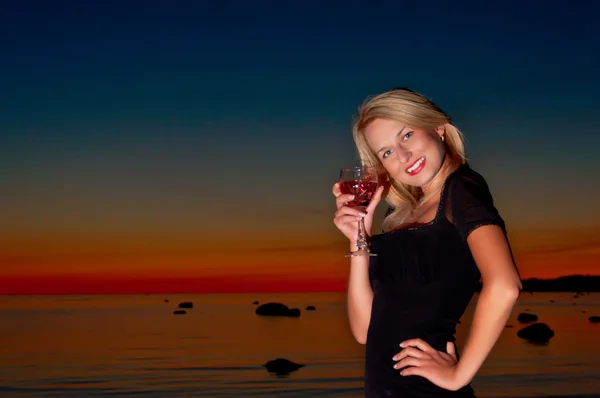 Kobieta pije koktajl nad oceanem — Zdjęcie stockowe