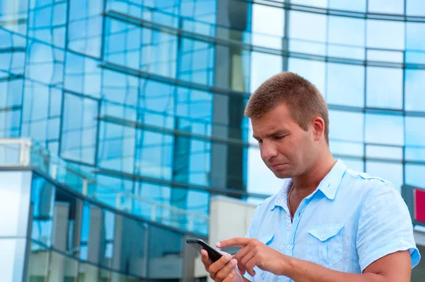 Hombre de negocios hablando por teléfono frente al moderno edificio de negocios —  Fotos de Stock