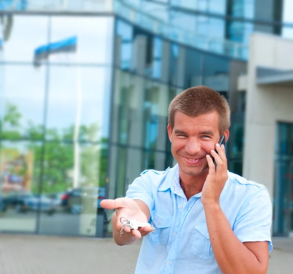 Homem de negócios falando ao telefone na frente do edifício de negócios moderno — Fotografia de Stock