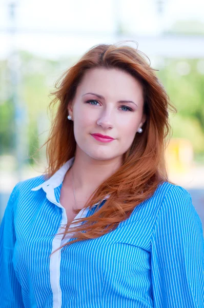 Femme d'affaires aux cheveux roux devant un immeuble de bureaux . — Photo