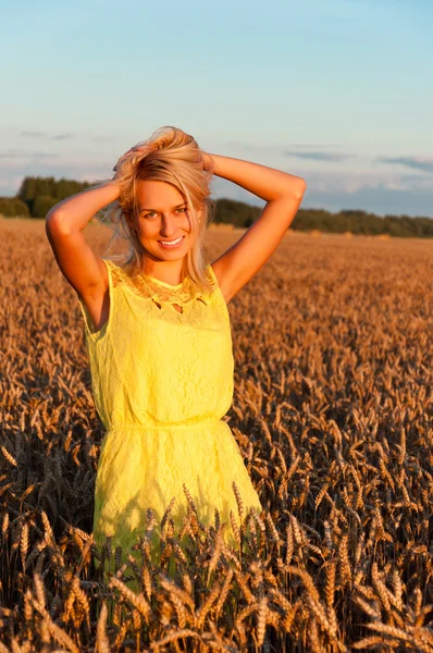 Glückliche Frau in gelbem Kleid in goldenem Weizen — Stockfoto