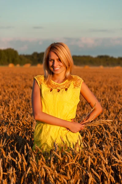 Vestido amarelo mulherengo feliz em trigo dourado — Fotografia de Stock