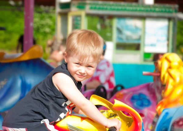 Gelukkig kleine jongen op de carrousel — Stockfoto