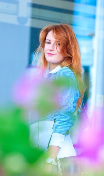 Mujer de negocios con el pelo rojo en frente del edificio de oficinas . —  Fotos de Stock