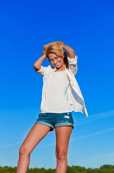 Schöne Frau in Jeans kurz und weiß Hemd posiert — Stockfoto