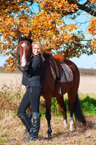 Kaunis nainen kävelee hevosen kanssa — kuvapankkivalokuva