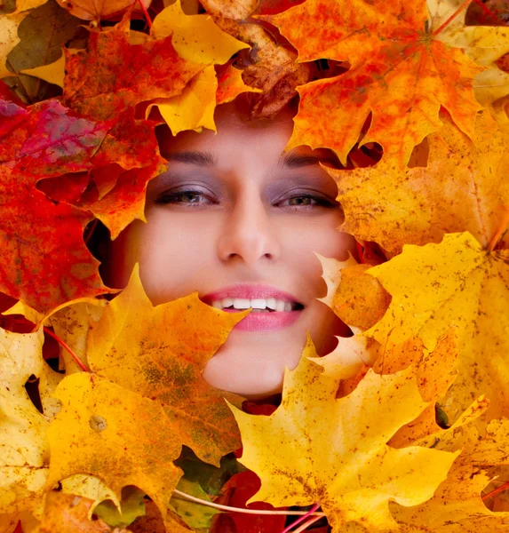 Beauty portrait of beautiful female face with autumn leaves — Stock Photo, Image