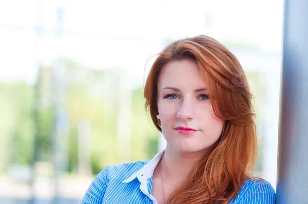 Mujer de negocios con el pelo rojo en frente del edificio de oficinas . — Foto de Stock