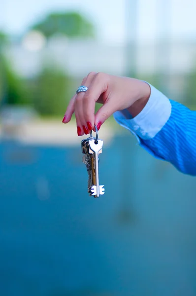 Klíče v ženě ruku na pozadí — Stock fotografie