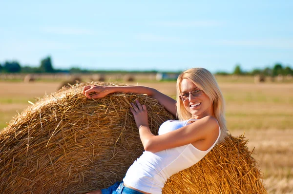 Sexy woman in a jeans shorts on field — Stock Photo, Image