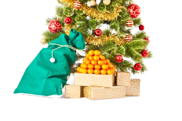 Kerstboom met giften en geschenken en mandarijnen — Stockfoto