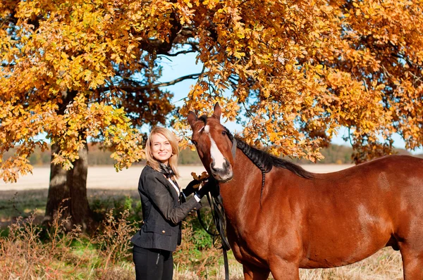 Hermosa mujer caminando con caballo — Foto de Stock