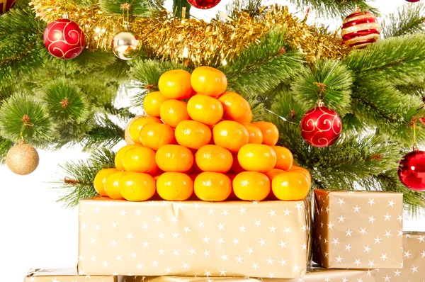 Kerstboom met giften en mandarijnen — Stockfoto