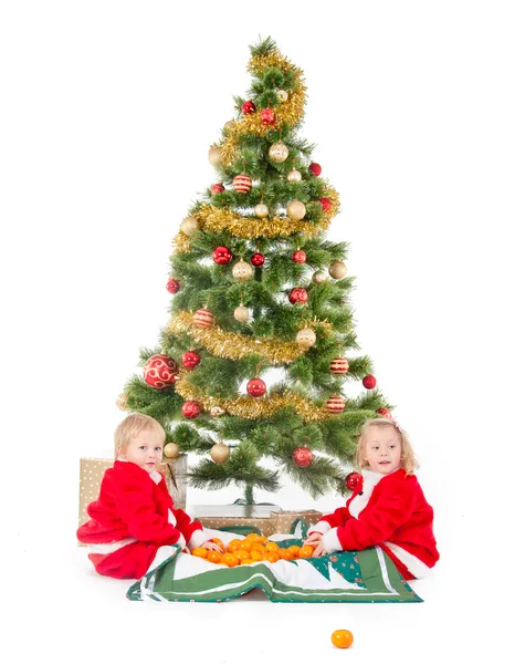 Duas crianças brincando sob a árvore de Natal — Fotografia de Stock