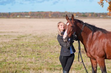 at ile yürüyen güzel genç gülümseyen kadın