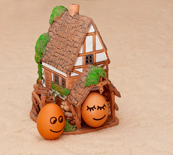 Due divertenti uova sorridenti vicino a una casa — Foto Stock