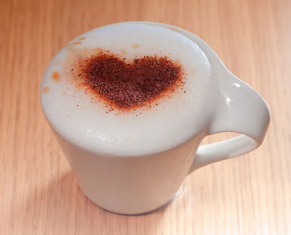Taza de café con corazón de canela en espuma de leche — Foto de Stock