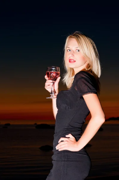 Schöne Frau im Sonnenuntergang am Strand. — Stockfoto