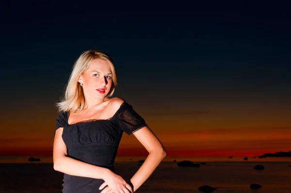 Hermosa mujer en la puesta de sol en la playa . — Foto de Stock