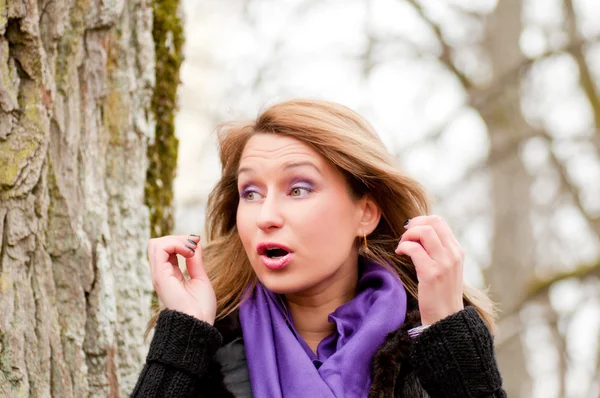 Schöne Mädchen posiert in der Natur in lila Kleid — Stockfoto