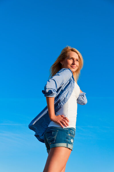 Beautiful woman in  short  posing on a wheat bale