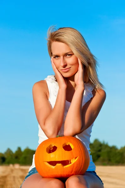 Mooie vrouw poseren in het kort op een tarwe-baal — Stockfoto