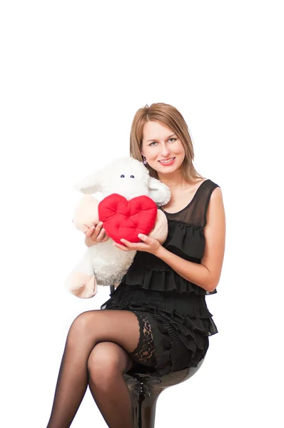 Hermosa mujer con un juguete de peluche y el corazón — Foto de Stock