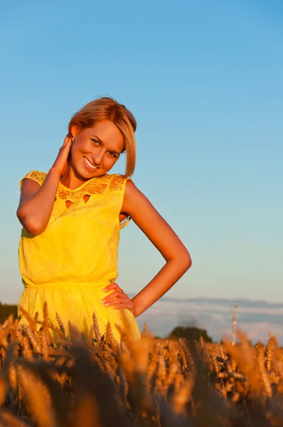 Happy womanin yellow dress  in golden wheat — Stock Photo, Image