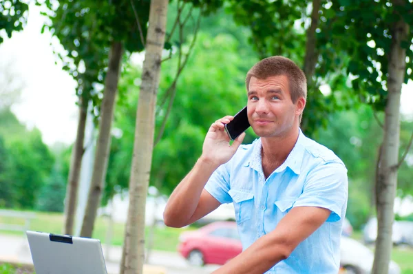 Homem de negócios com laptop e telefone celular — Fotografia de Stock