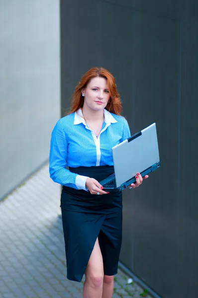 Mulher de negócios posando com um laptop — Fotografia de Stock