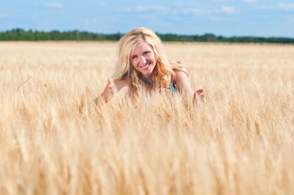 Счастливое женское голубое платье в золотой пшенице — стоковое фото